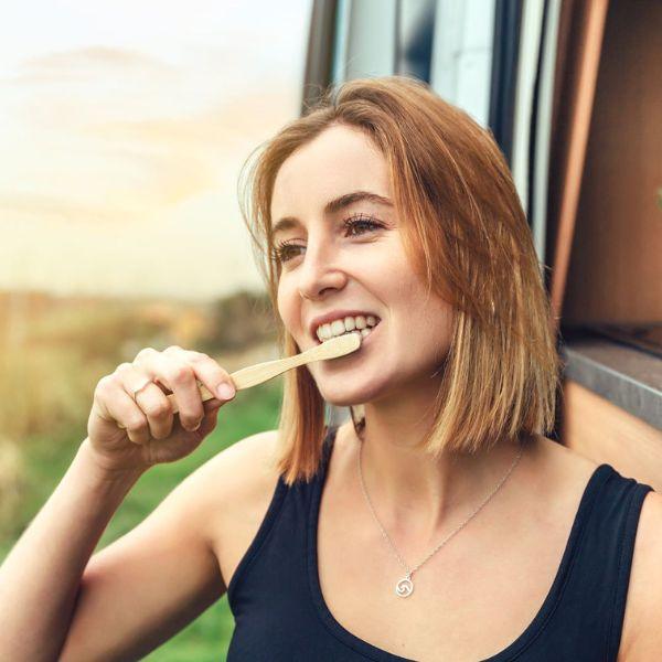 Bamkiki_Sustainable_Eco_Friendly_zero waste oral care bamboo toothbrush adult size woman brushing teeth outdoor
