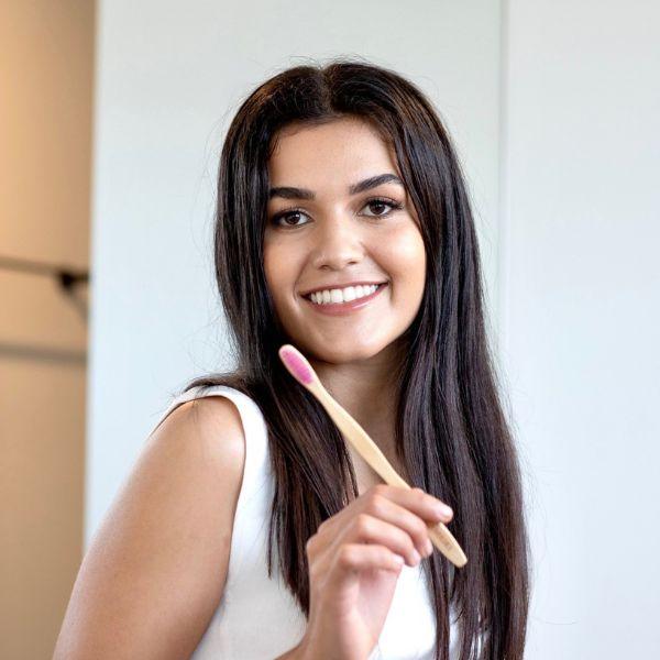 Bamkiki_Sustainable_Eco_Friendly_zero waste oral care bamboo toothbrush with pink colour bristle happy customer review woman holding