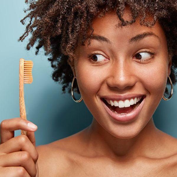 Bamkiki_Sustainable_Eco_Friendly_zero waste oral care bamboo toothbrush  adult size woman holding one pieces naturel colour